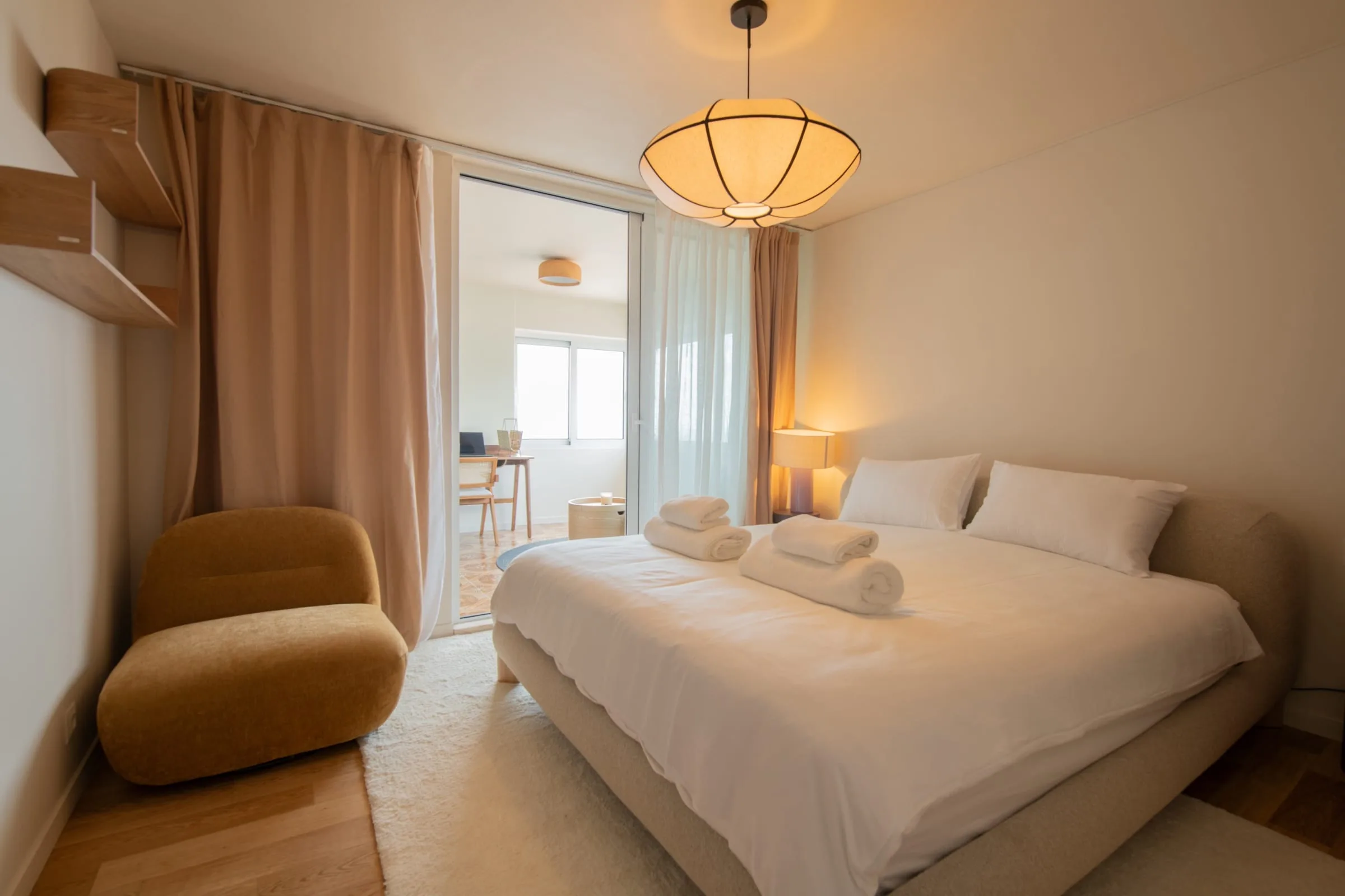 A guest bedroom prepared with fresh towels and warm lighting