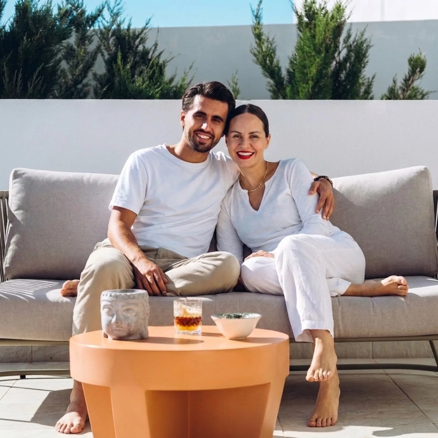 A couple relaxing on an outdoor sofa