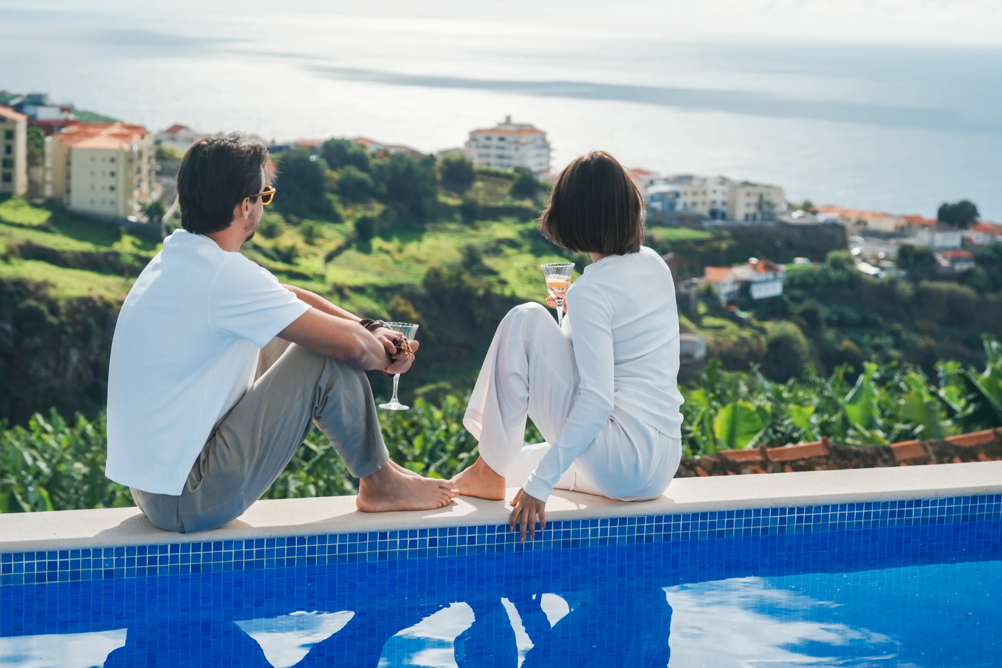Guests by the pool, looking out over the ocean and the coast